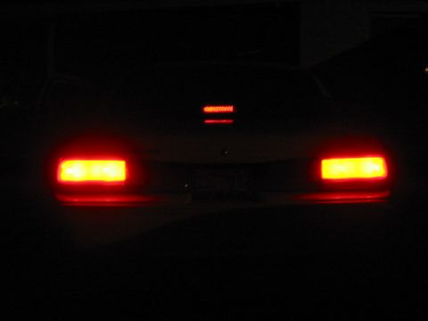 1997 Ford Crown Victoria - The rear of a 1997 Ford Crown Victoria is visible at night, with its brake lights and center high-mounted stop lamp illuminated.