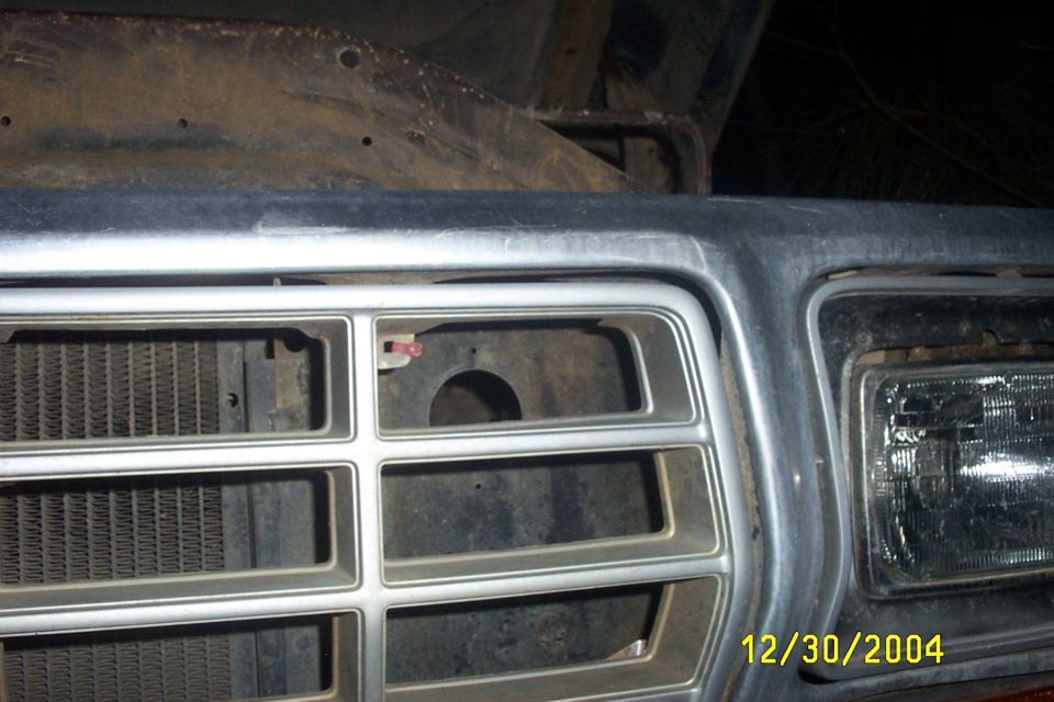 1979 Ford F-150 grille and headlight assembly, chrome trim, some rust on hood support
