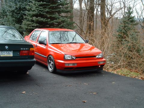 1994 Volkswagen Jetta - Red Volkswagen Jetta sedan parked on asphalt driveway next to another car.