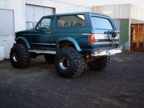 1996 Ford Bronco - This modified Ford Bronco features a lifted suspension and large off-road tires, giving it an aggressive stance.