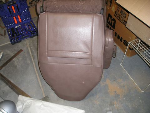 1996 Ford Bronco - A brown car seat is shown with a toolbox and cardboard boxes in the background.