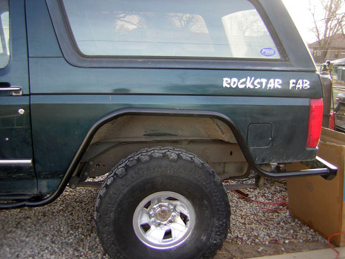 Green Ford Bronco rear quarter with wheel off, tube bumper, 'ROCKSTAR FAB' text