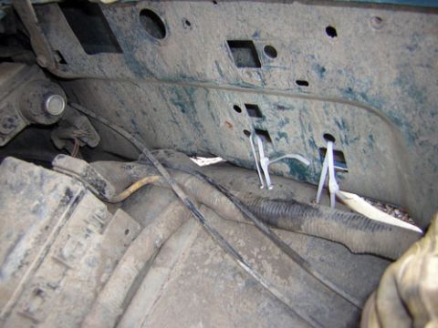 1995 Ford Bronco - Undercarriage view of a green vehicle, showing wiring and a secured panel.