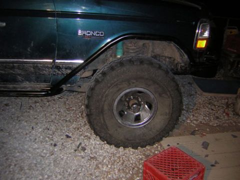 1995 Ford Bronco - The fender badge confirms this is a 1995 Ford Bronco, equipped with large off-road tires.