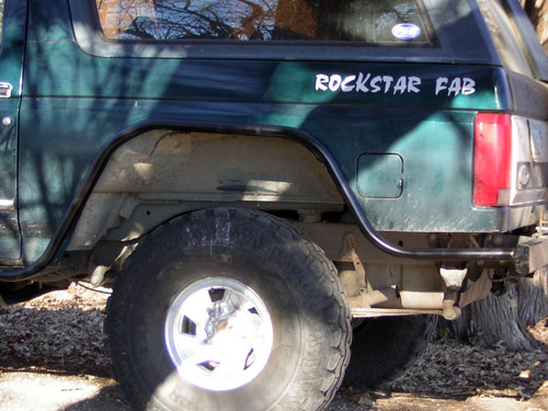 Dark-green SUV rear quarter with 'Rockstar Fab' decal and chrome wheel