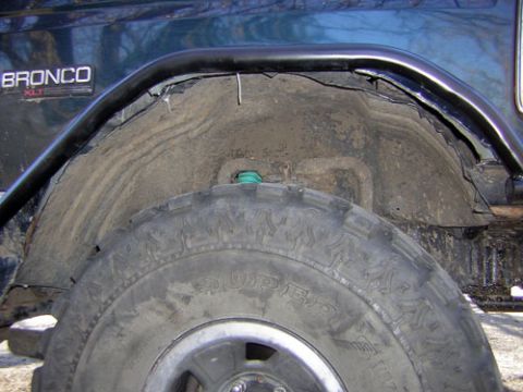 1995 Ford Bronco - Close-up of the rear wheel well and tire on a 1995 Ford Bronco XLT, an aftermarket roll bar.