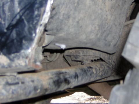 1995 Ford Bronco - Undercarriage view showing frame and suspension parts, tire on the right.