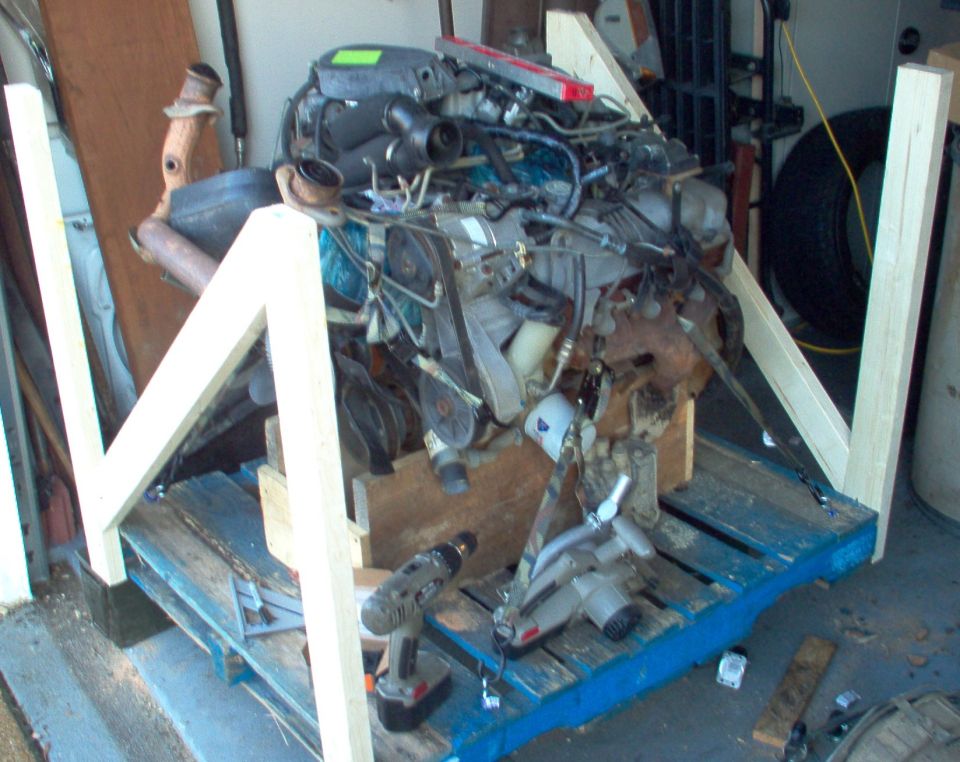 V8 engine inside a homemade wood engine stand frame on a pallet