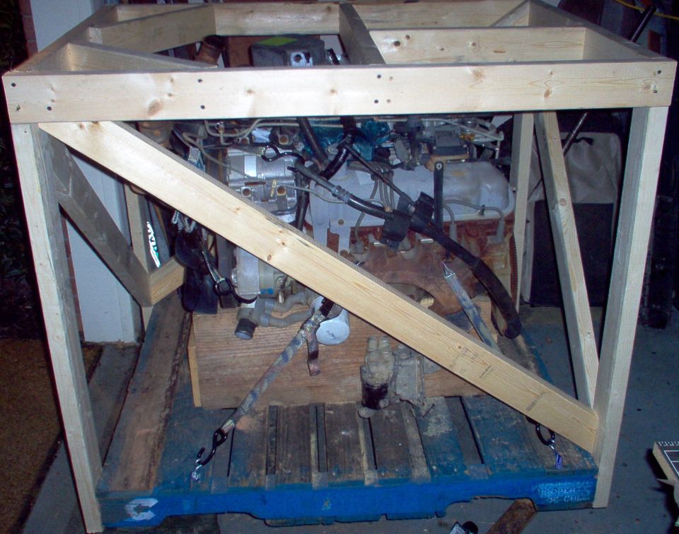 Wood-framed engine stand with engine and intake visible through braces