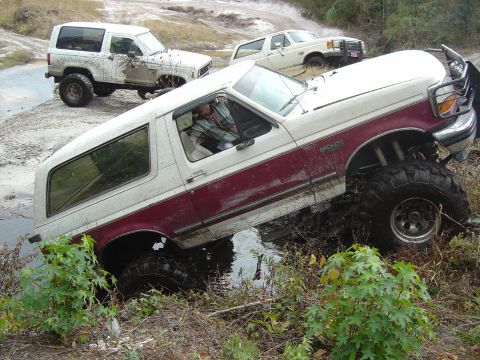 1993 Ford Bronco - This 1993 Ford Bronco is stuck in the mud, with two other vehicles visible in the background.