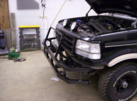1993 Ford Bronco - A black Ford Bronco is shown with its hood up and a heavy-duty aftermarket bumper installed.