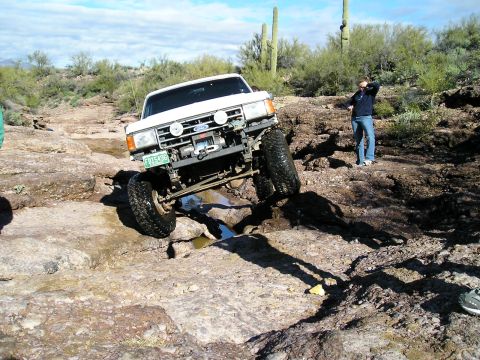 1993 Ford Bronco - Ford Bronco tackling a challenging off-road course with saguaro cacti in the background.