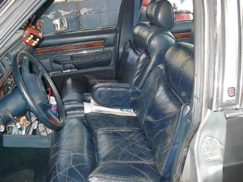 1989 Ford Crown Victoria LTD - The interior of a 1989 Ford Crown Victoria LTD features blue leather seats and wood grain trim on the door panels.