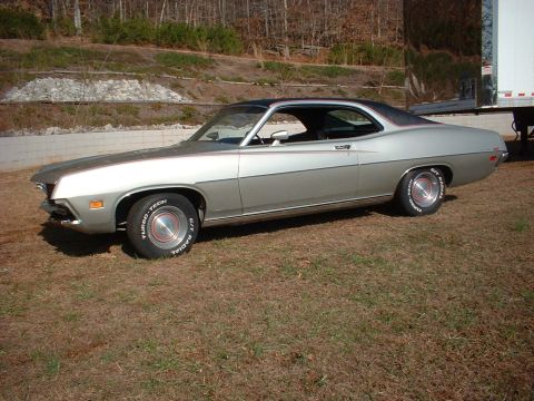 1971 Ford Torino - This two-tone coupe features a distinctive body style and is parked outdoors near a large trailer.