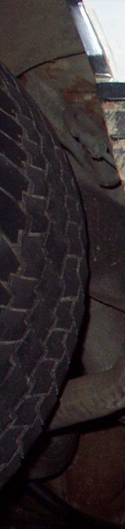 1985 Ford Crown Victoria LTD - Close-up view of a spare tire and the undercarriage of a vehicle.