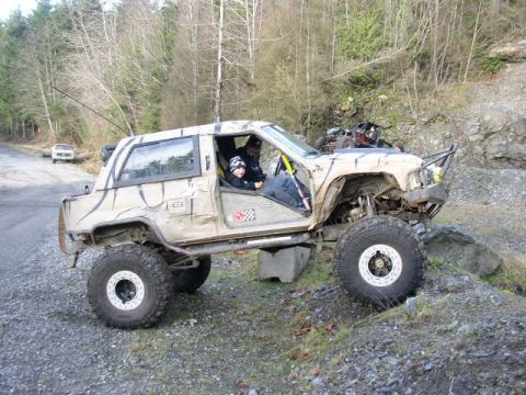 1978 Ford Bronco - This heavily modified off-road vehicle navigates a challenging rocky terrain, with another vehicle visible in the background.