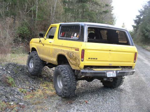 1978 Ford Bronco - 1978 Ford Bronco with custom off-road tires on a gravel road.