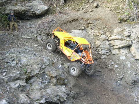 1978 Ford Bronco - A yellow off-road buggy navigates a steep, rocky incline during an off-road event.