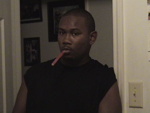 1995 Mazda 626 - A man is shown indoors with a pink object held between his teeth.