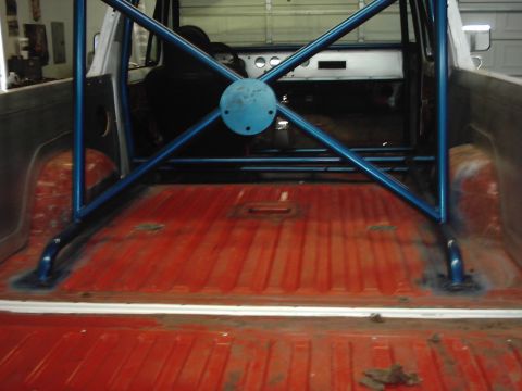 1978 Ford Bronco - The interior of a vehicle is shown, focusing on the bed area with a prominent blue roll cage.