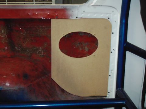 1978 Ford Bronco - An interior panel with a cutout for a speaker reveals the red interior of the vehicle.