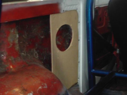 1978 Ford Bronco - Custom interior panel with a speaker cutout, showing red painted metal and blue roll cage tubing.
