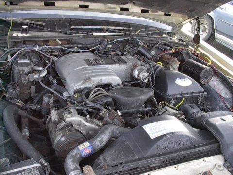 1985 Ford Crown Victoria LTD - The engine bay of a 1985 Ford Crown Victoria LTD shows its V8 engine and associated components under an open hood.