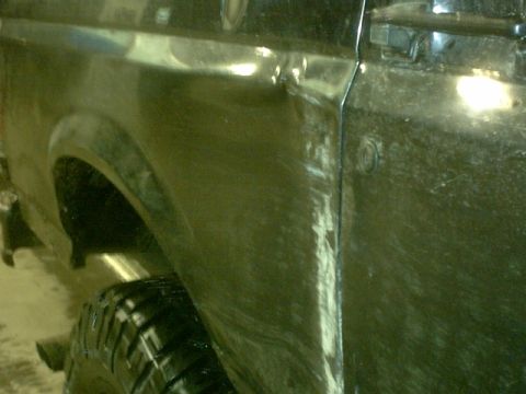 1995 Ford Bronco - Close-up view of the rear fender and door seam on a dark-colored SUV.