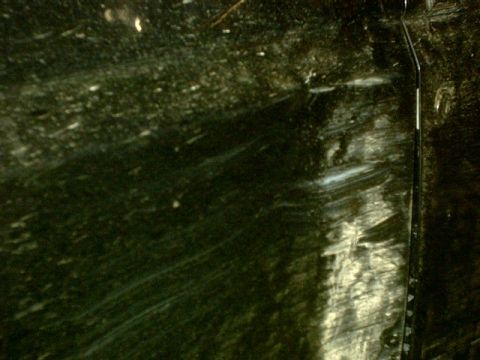 1995 Ford Bronco - Close-up of a damaged dark surface with a Supermotors.net watermark.