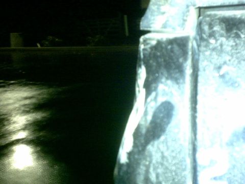 1995 Ford Bronco - Close-up of a damaged vehicle part, showing chipped paint and metal.