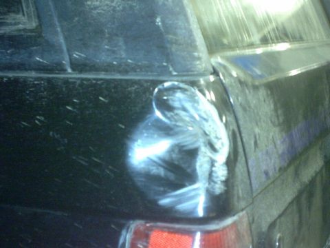 1995 Ford Bronco - Damage to the rear quarter panel of a black vehicle.