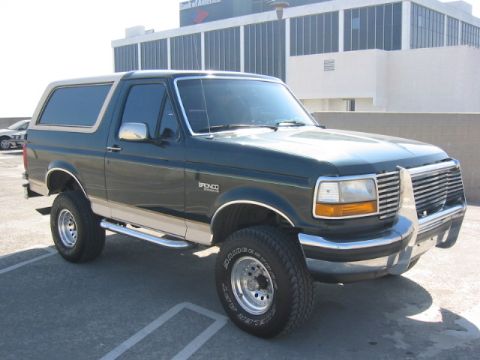 1992 Ford Bronco - This Ford Bronco is parked in a lot with a building behind it.