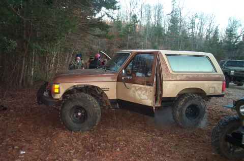 1987 Ford Bronco - Modified 1987 Ford Bronco with lifted suspension in a wooded area.