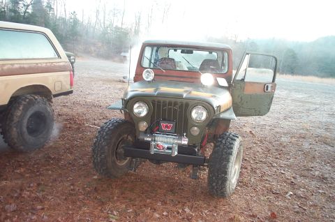 1987 Ford Bronco - A vintage Jeep CJ-5 with a winch is parked next to a Ford Bronco in an outdoor setting.