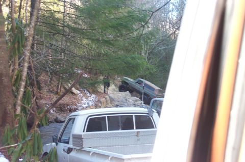 1987 Ford Bronco - Two off-road vehicles are seen on a challenging trail in a wooded area, with one vehicle appearing to be a 1978 Ford Bronco.