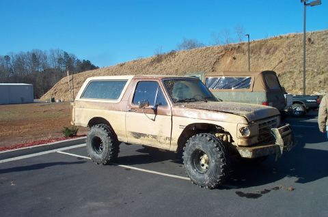 1987 Ford Bronco - This modified 1980s Ford Bronco appears to be in rough condition with significant body damage and rust.