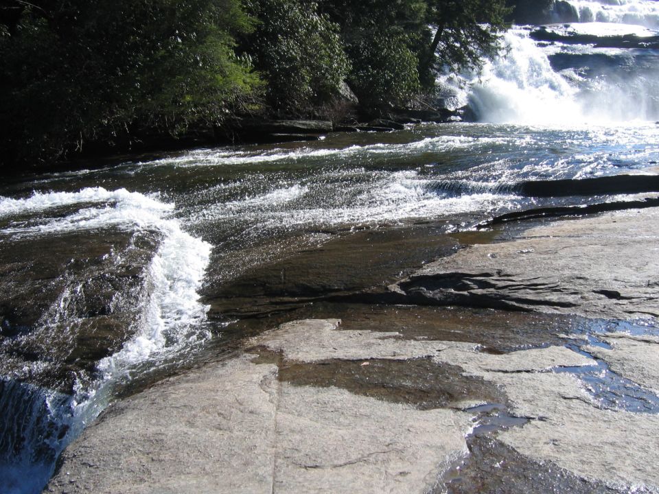 water flowing over rocks near a waterfall