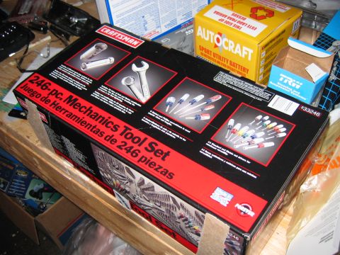 1985 Ford LTD Crown Victoria - A Craftsman 246-piece mechanics tool set is displayed on a wooden surface, surrounded by other boxes and items.
