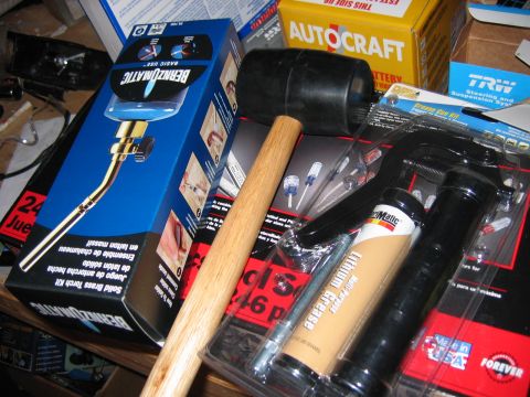 1985 Ford LTD Crown Victoria - Collection of automotive tools and parts, including a Bernzomatic torch kit and grease gun.
