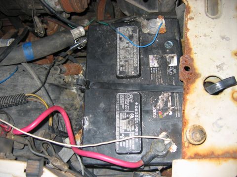 1985 Ford LTD Crown Victoria - Close-up view of two batteries and wiring in a vehicle's engine bay.