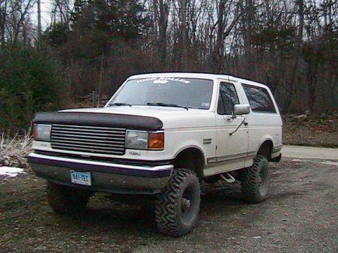 1989 Ford Bronco - This lifted Ford Bronco sits parked outdoors, its large tires hinting at off-road capabilities.