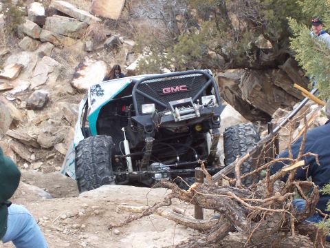 1991 Ford Bronco - Modified off-road vehicle navigating a rocky trail with a prominent GMC grille.