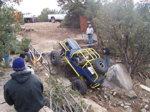 1991 Ford Bronco - Off-road buggy tackling a challenging rocky incline on a trail system.