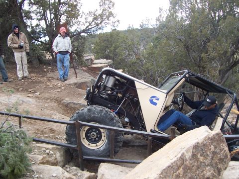 1991 Ford Bronco - Custom buggy with Cummins branding tackles a challenging off-road obstacle on a trail.