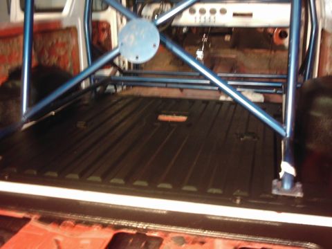 1978 Ford Bronco - The interior of a 1978 Ford Bronco shows a newly applied black bedliner and a blue roll cage.