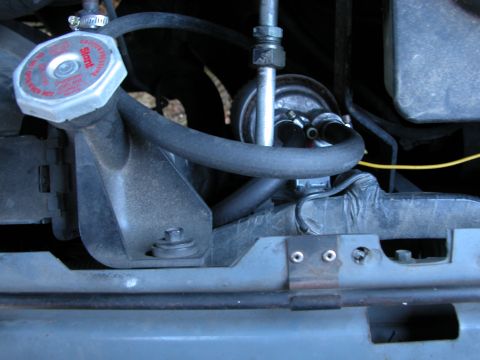 1990 Ford Bronco - Close-up view of engine components including a radiator cap and hoses.