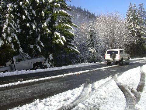 1978 Ford Bronco - A 1978 Ford Bronco tows a stuck pickup truck on a snow-covered road.