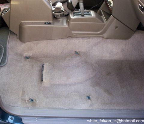 2000 Mitsubishi Montero - Interior view of a 2000 Mitsubishi Montero with front seats removed, revealing the carpet and center console area.