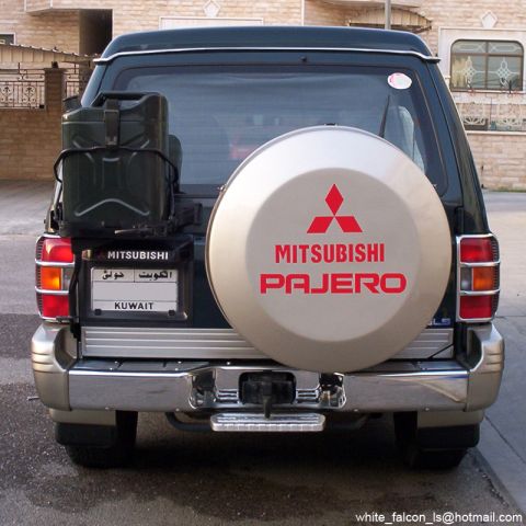 2000 Mitsubishi Montero - The rear of a dark green SUV is shown, a spare tire cover with Mitsubishi Pajero branding and a license plate from Kuwait.