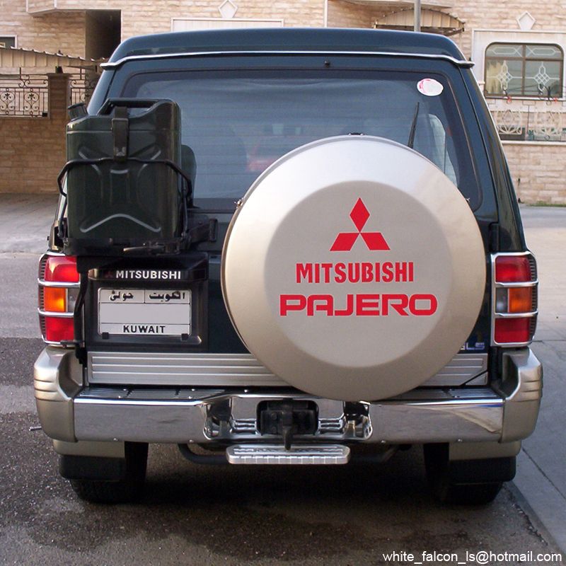 Rear of dark green Mitsubishi Pajero with branded spare cover and jerry cans